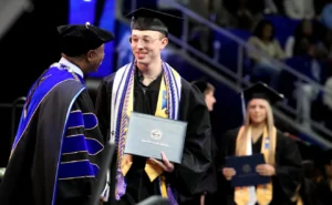 MTSU graduate Nolan Willis Jr. shakes the hand of MTSU President Sidney McPhee as he accepts his diploma and walks across the stage during MTSU’s 2023 Fall Graduation Ceremony on Saturday, Dec. 16, 2023 HELEN COMER/The Daily News Journal